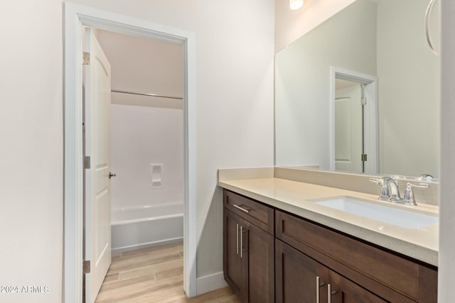 full bath with shower / bathing tub combination, wood finished floors, and vanity