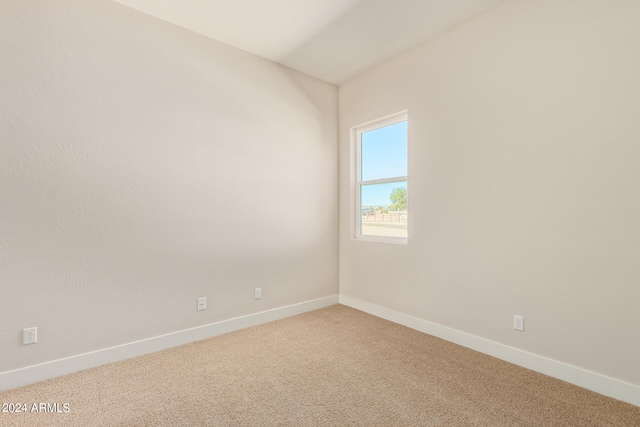 carpeted empty room featuring baseboards