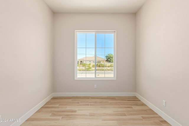 unfurnished room with baseboards and light wood finished floors