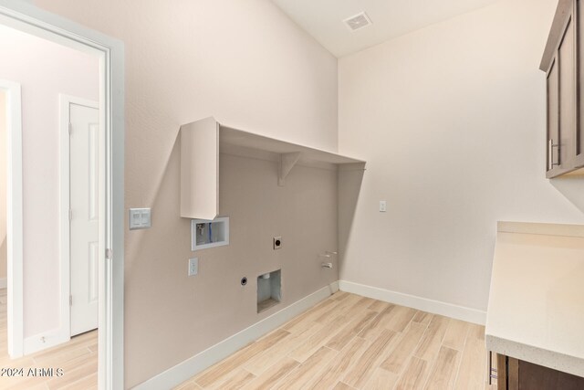 washroom with visible vents, laundry area, light wood finished floors, and electric dryer hookup