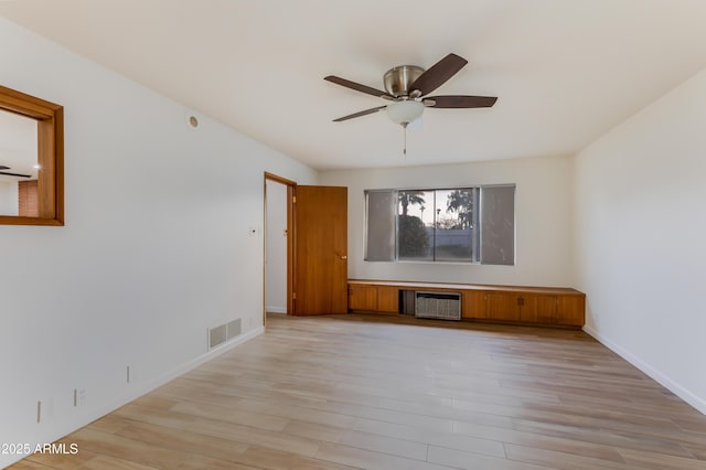 spare room featuring ceiling fan, light hardwood / wood-style flooring, and radiator heating unit