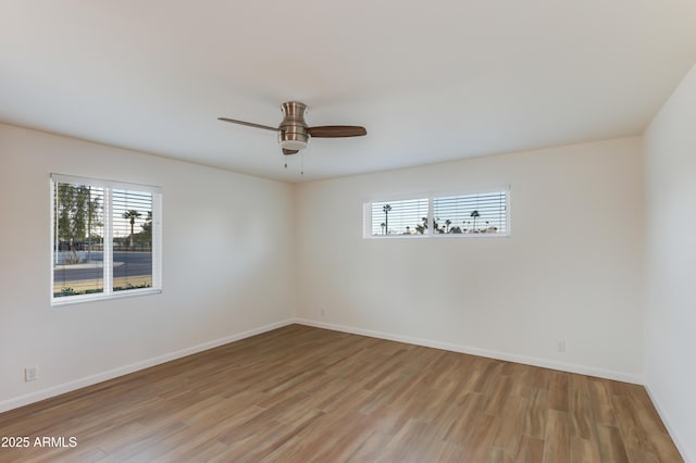 spare room with plenty of natural light, ceiling fan, and light hardwood / wood-style flooring