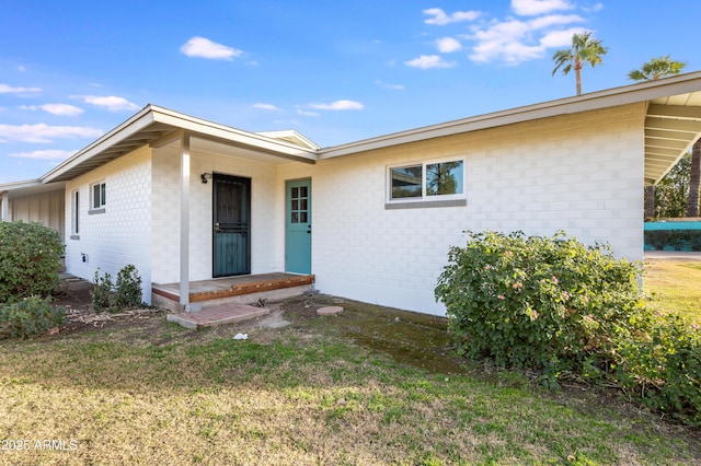 property entrance with a lawn