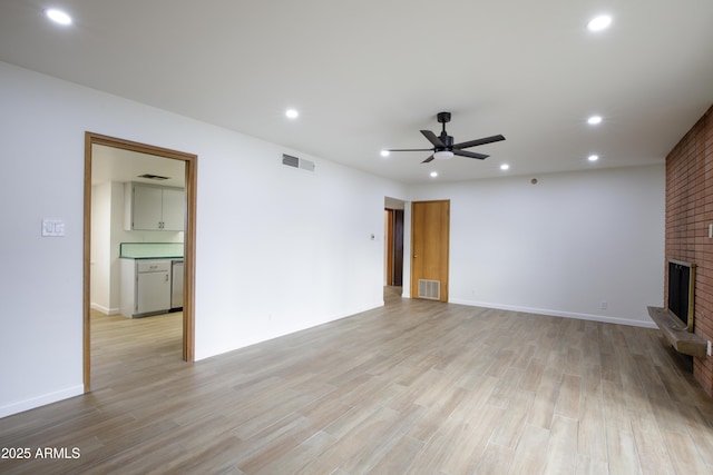 unfurnished living room with a fireplace, light hardwood / wood-style floors, and ceiling fan