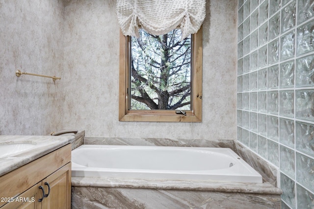 bathroom with a relaxing tiled tub and vanity