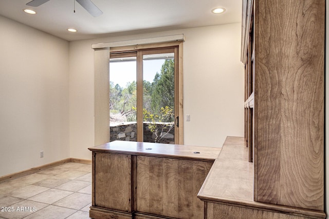 unfurnished office featuring light tile patterned floors and ceiling fan