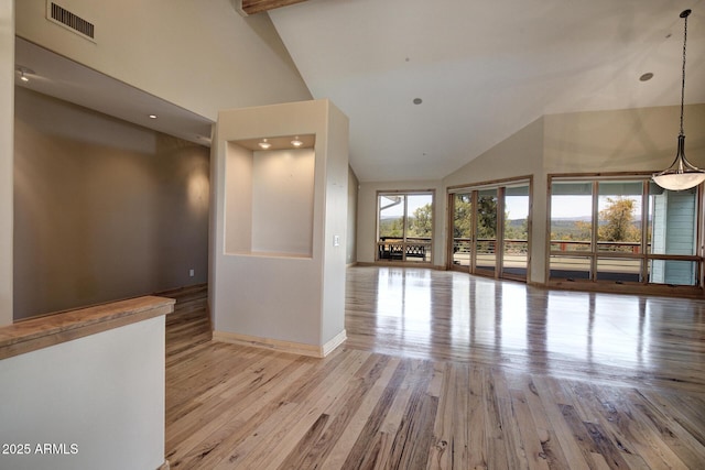 unfurnished room featuring high vaulted ceiling and light hardwood / wood-style flooring