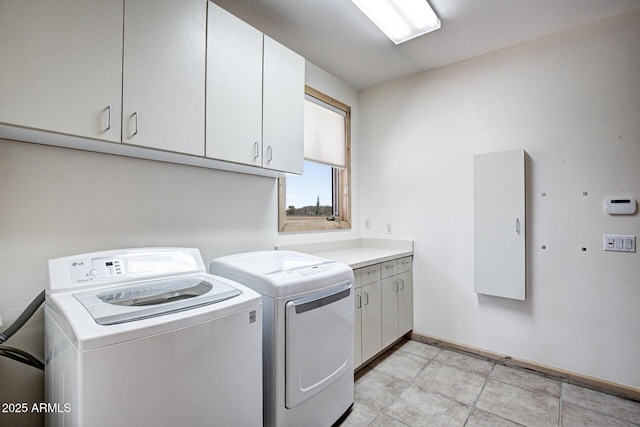 clothes washing area featuring cabinets and independent washer and dryer