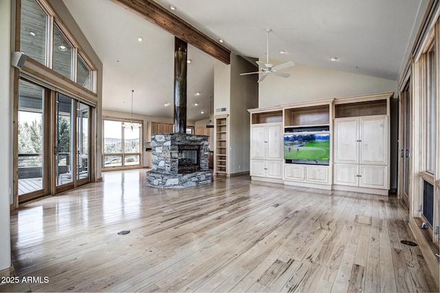 unfurnished living room featuring ceiling fan, high vaulted ceiling, a fireplace, beamed ceiling, and light wood-type flooring