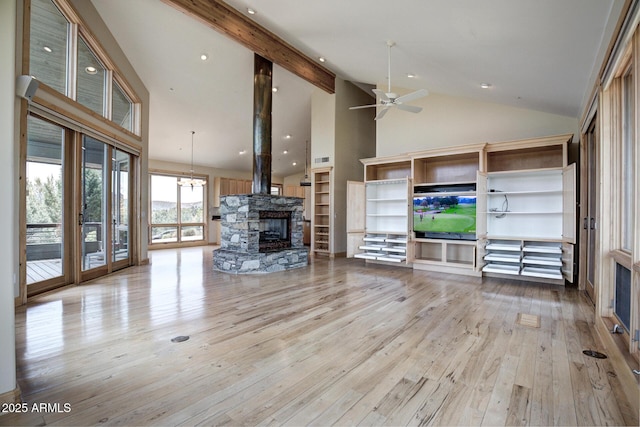 unfurnished living room with a stone fireplace, high vaulted ceiling, ceiling fan, light hardwood / wood-style floors, and beam ceiling