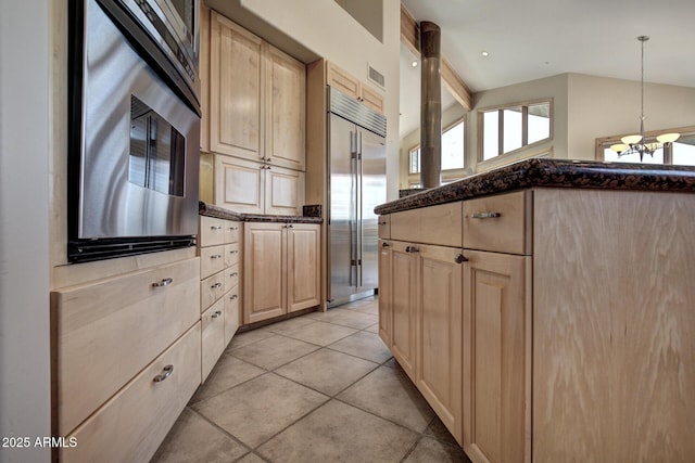 kitchen with decorative light fixtures, stainless steel built in refrigerator, lofted ceiling, light tile patterned floors, and light brown cabinets