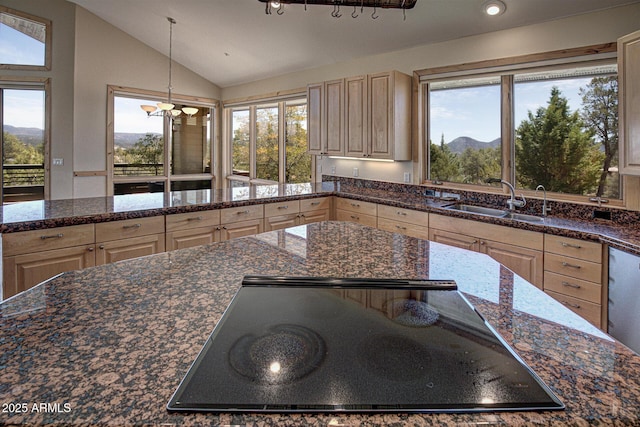 kitchen featuring lofted ceiling, stovetop, sink, a mountain view, and pendant lighting