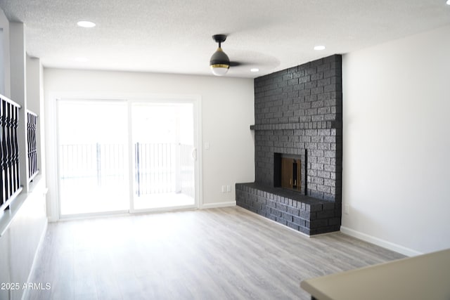 1632 E Saint Charles Ave, Phoenix, AZ 85042 - unfurnished living room with wood finished floors, a textured ceiling, a fireplace, and recessed lighting