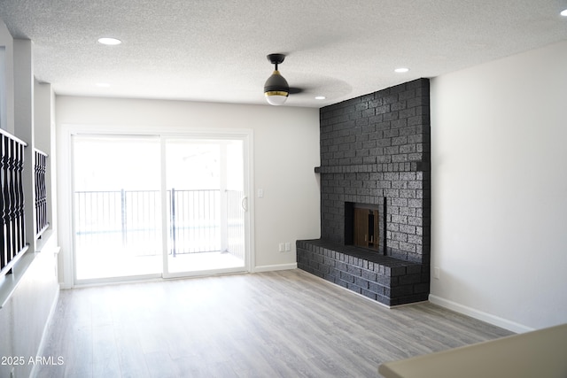 1632 E Saint Charles Ave, Phoenix, AZ 85042 - unfurnished living room with a textured ceiling, wood finished floors, recessed lighting, and a brick fireplace