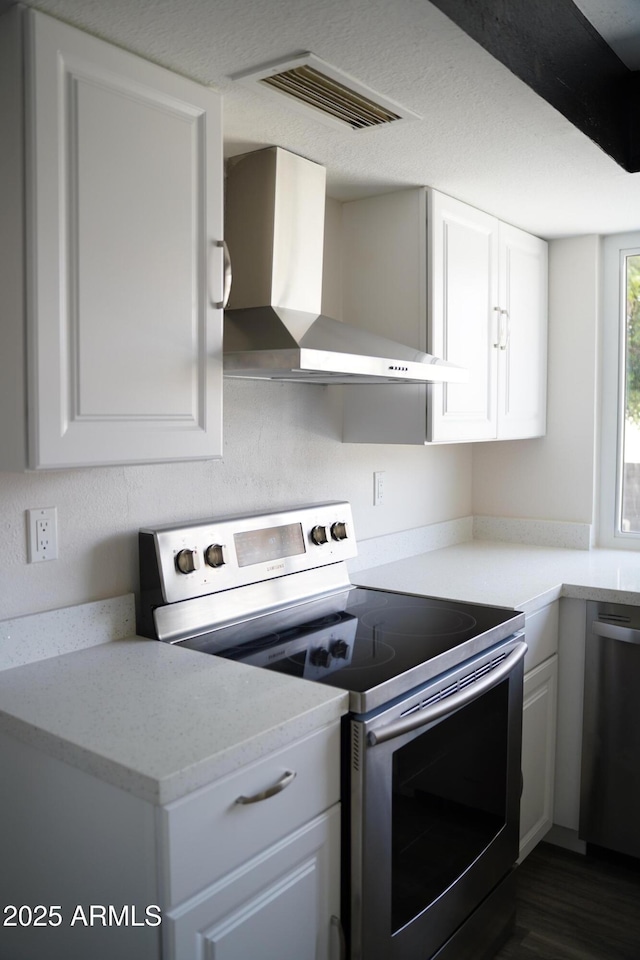 1632 E Saint Charles Ave, Phoenix, AZ 85042 - kitchen featuring appliances with stainless steel finishes, wall chimney range hood, white cabinets, and dark wood-style flooring