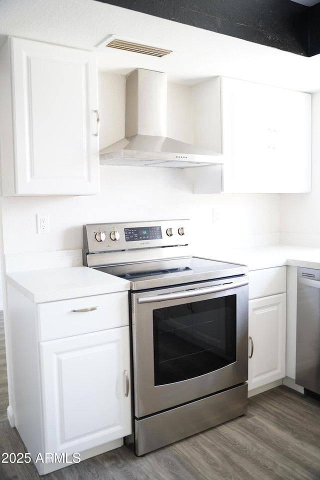 1632 E Saint Charles Ave, Phoenix, AZ 85042 - kitchen featuring appliances with stainless steel finishes, wall chimney exhaust hood, wood finished floors, white cabinetry, and light countertops