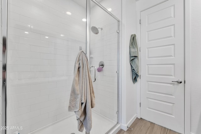 full bath featuring a shower stall and wood finished floors