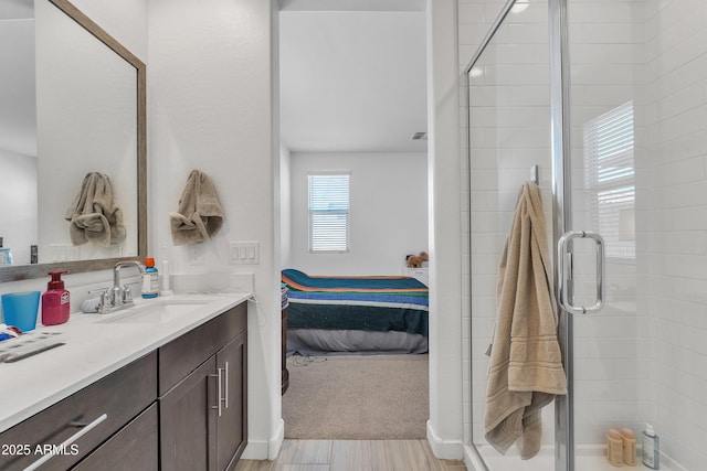 ensuite bathroom featuring wood finished floors, a stall shower, connected bathroom, and vanity