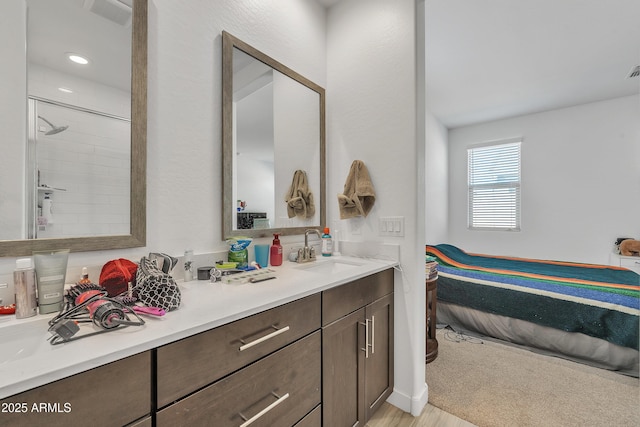 full bath with a tile shower, vanity, and visible vents