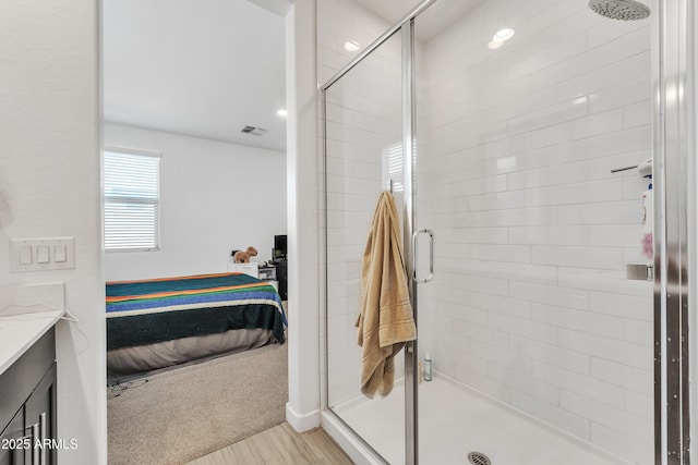 ensuite bathroom featuring a stall shower, vanity, visible vents, and ensuite bathroom