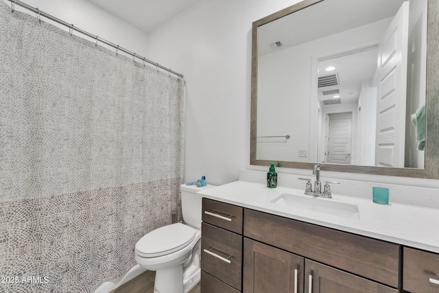 full bathroom with toilet, visible vents, and vanity