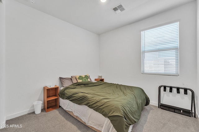 bedroom with baseboards, visible vents, and light colored carpet