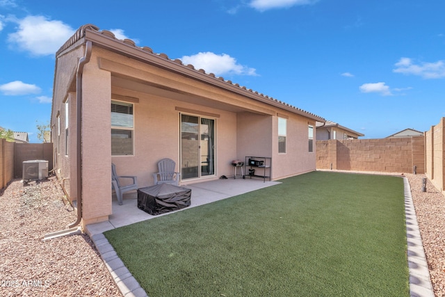 back of property with stucco siding, a patio area, a fenced backyard, and central air condition unit