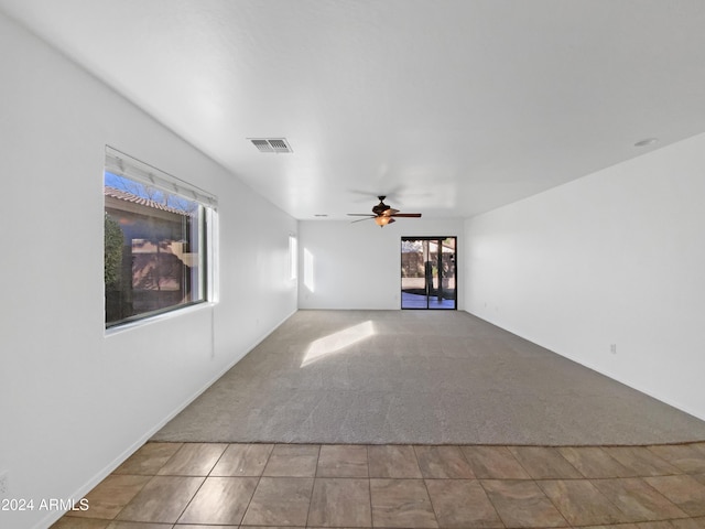 unfurnished living room featuring ceiling fan and light colored carpet