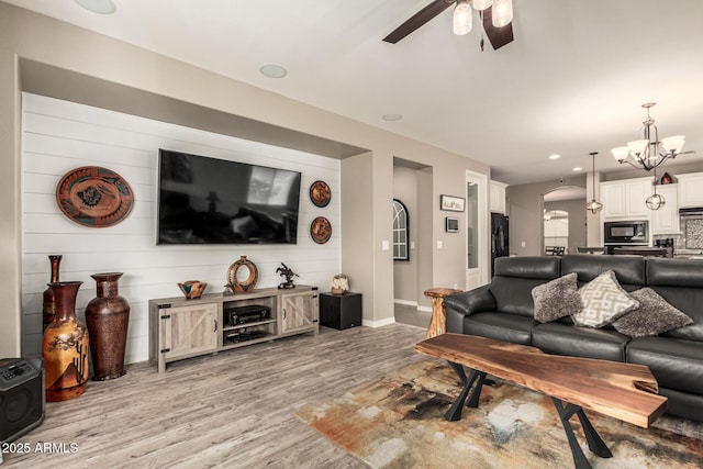 1078 W Redwood Ave, Queen Creek, AZ 85140 - living room featuring light wood finished floors, baseboards, recessed lighting, arched walkways, and ceiling fan with notable chandelier