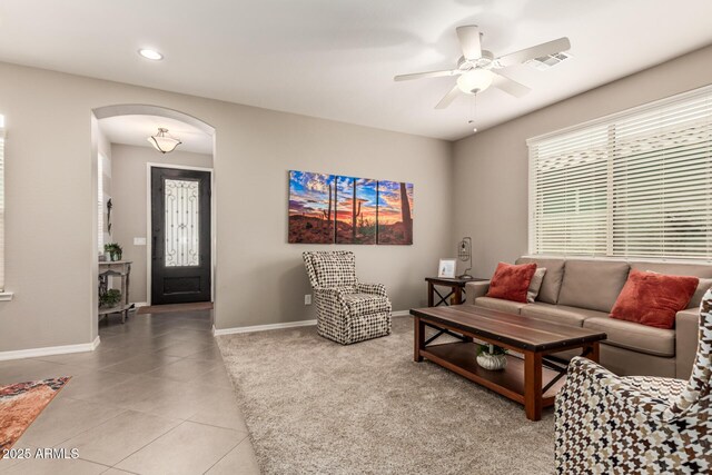 1078 W Redwood Ave, Queen Creek, AZ 85140 - living room with light tile patterned flooring, a ceiling fan, baseboards, visible vents, and arched walkways