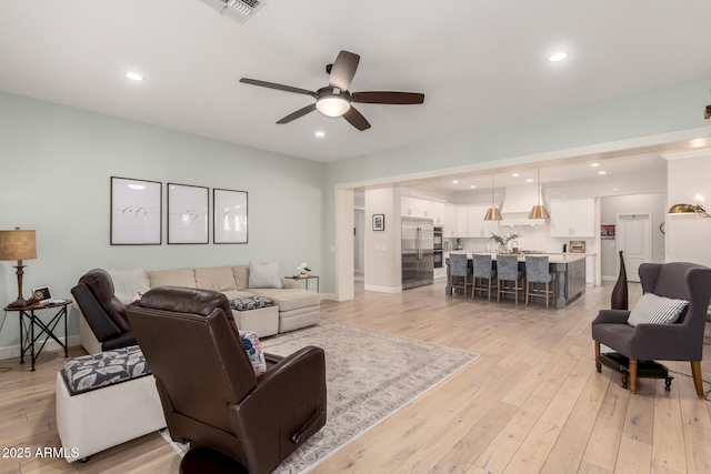living area with a ceiling fan, light wood-style floors, baseboards, and recessed lighting