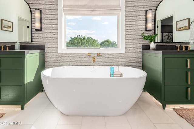 full bathroom featuring two vanities and a freestanding bath