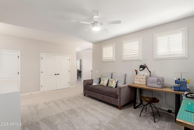 living area with carpet, healthy amount of natural light, and ceiling fan