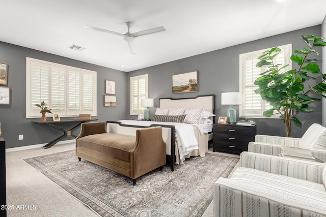 bedroom featuring light colored carpet, a ceiling fan, and baseboards