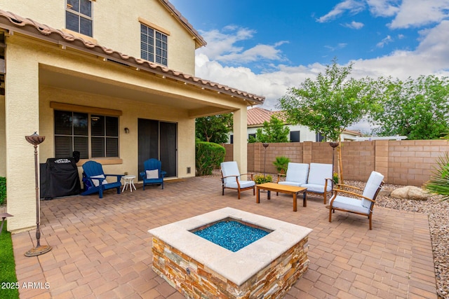 view of patio / terrace with fence and an outdoor living space with a fire pit