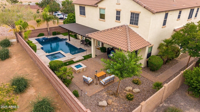 view of pool with a patio, a fenced backyard, outdoor lounge area, and a pool with connected hot tub