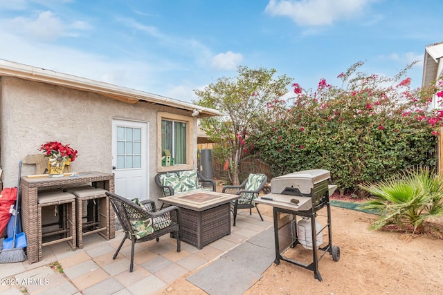 view of patio / terrace featuring an outdoor fire pit, a grill, and fence
