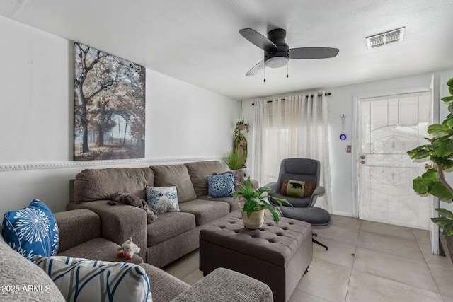 living area with a ceiling fan, visible vents, and light tile patterned floors