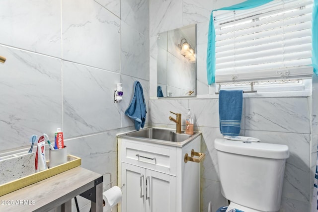 bathroom with tile walls, vanity, and toilet
