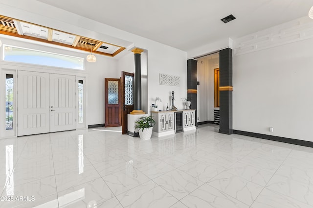 10417 N 180th Dr, Waddell, AZ 85355 - foyer featuring wine cooler, marble finish floor, baseboards, and ornate columns