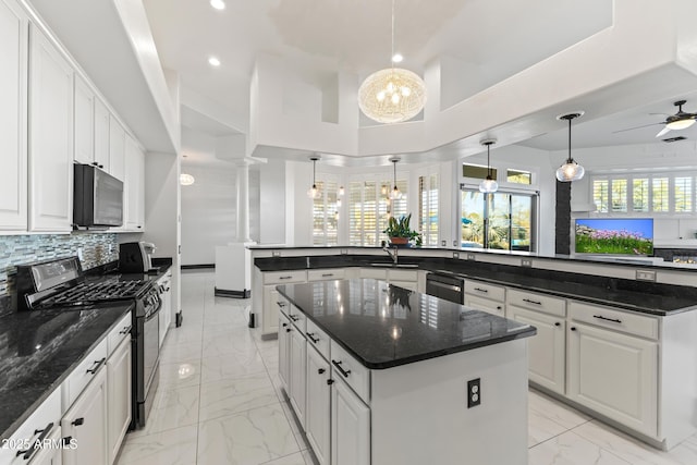 10417 N 180th Dr, Waddell, AZ 85355 - kitchen with black dishwasher, a kitchen island, marble finish floor, stainless steel range with gas cooktop, and pendant lighting