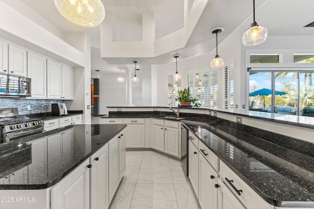 10417 N 180th Dr, Waddell, AZ 85355 - kitchen with a large island, marble finish floor, stainless steel appliances, white cabinetry, and pendant lighting