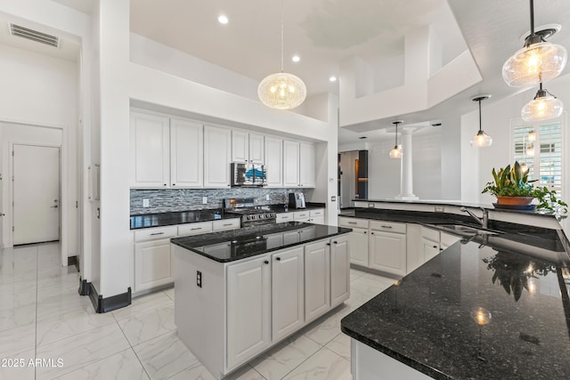 10417 N 180th Dr, Waddell, AZ 85355 - kitchen with a kitchen island, hanging light fixtures, marble finish floor, stainless steel appliances, and white cabinetry
