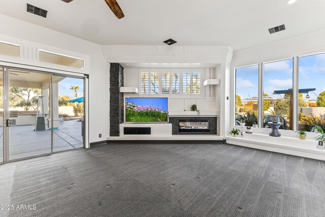 10417 N 180th Dr, Waddell, AZ 85355 - unfurnished living room featuring a glass covered fireplace, carpet flooring, ceiling fan, and visible vents