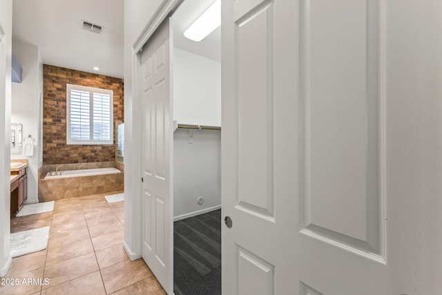 10417 N 180th Dr, Waddell, AZ 85355 - bathroom with tile patterned flooring, vanity, visible vents, a bath, and a walk in closet