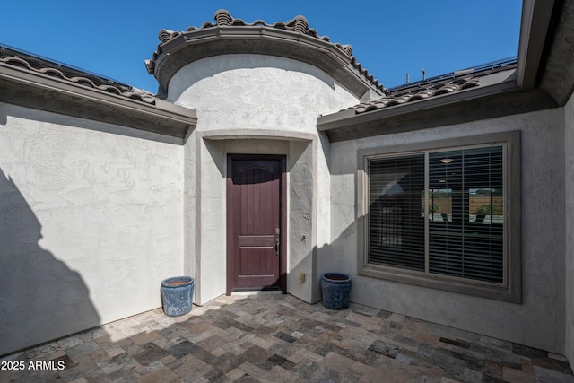 view of exterior entry featuring a patio area