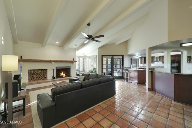 living room featuring beam ceiling, ceiling fan, tile patterned floors, and high vaulted ceiling