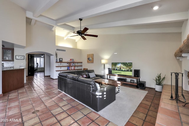 tiled living room featuring ceiling fan, high vaulted ceiling, and beam ceiling