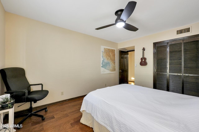 bedroom featuring ceiling fan, a closet, and dark wood-type flooring