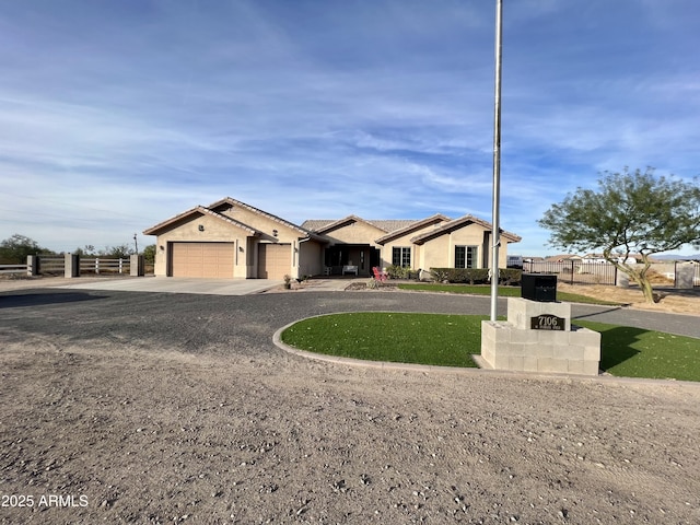 ranch-style home featuring driveway, fence, and stucco siding